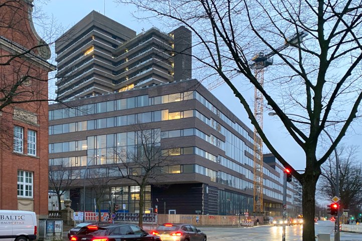 Straßenkreuzung, Hochhaus und Baukran bei regnerischem Wetter